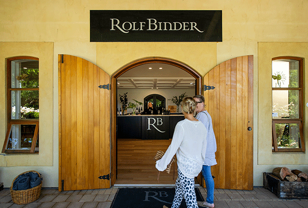 Front view of the Rolf Binder cellar door with a man and woman walking up to its wooden door