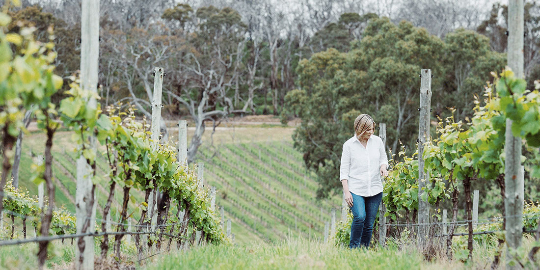 Blonde woman walks through vineyard