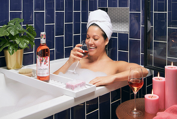 a woman in a bath drinks a glass of echo falls wine